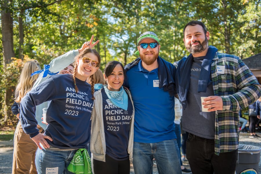 Photo of employees at field day event posing together in event t-shirts