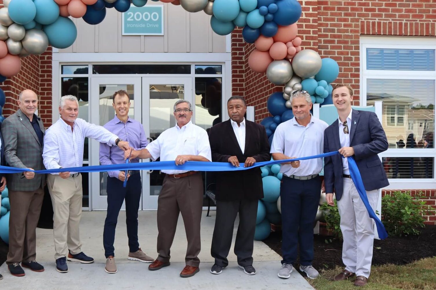 Photo of the Bonaventure team cutting a ribbon outside of building opening