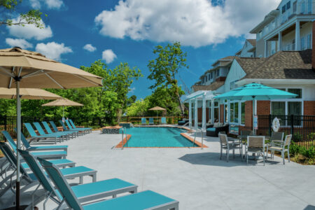 Photo of a pool and the surrounding area with sun chairs and umbrellas